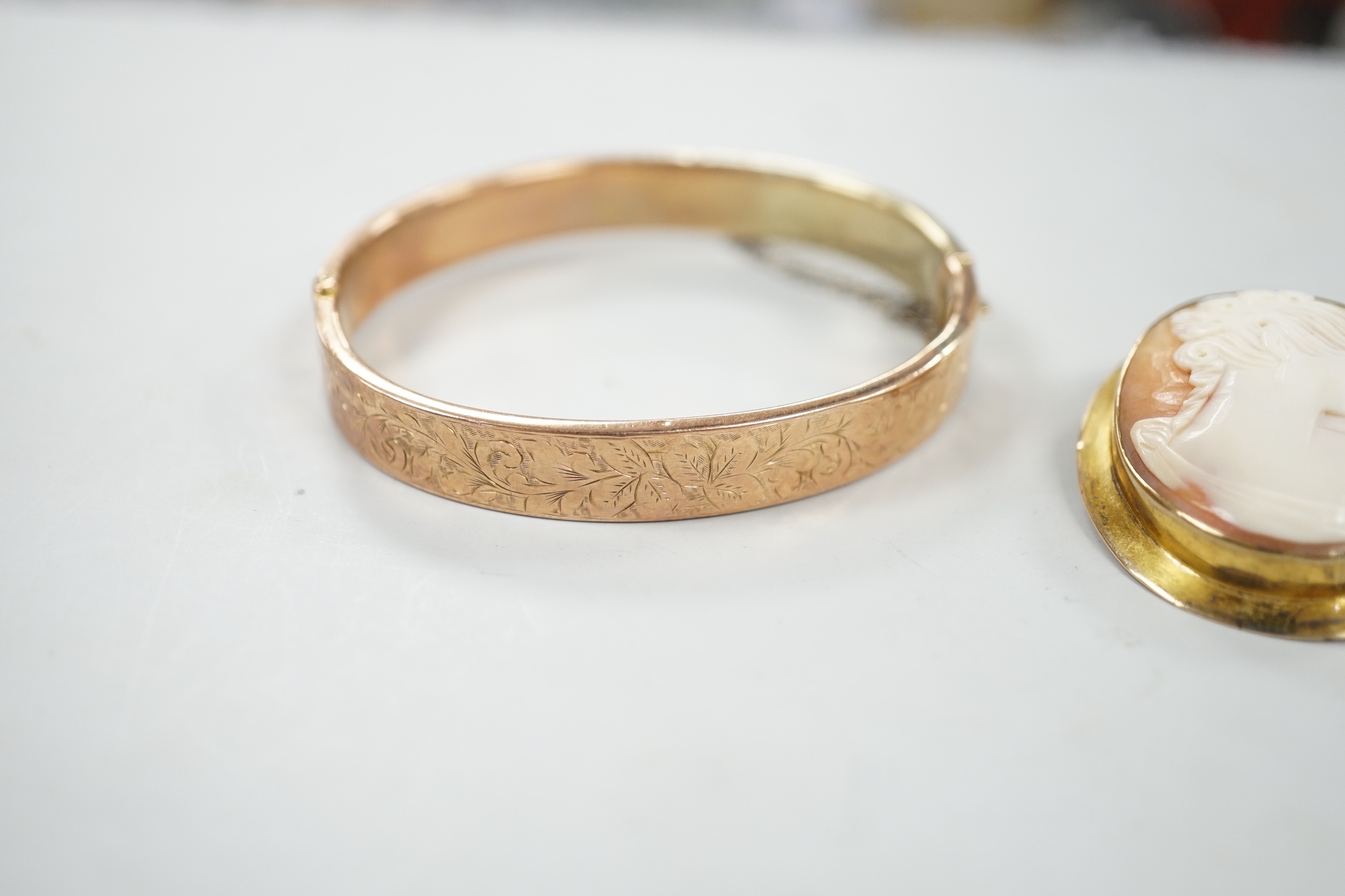 A 9ct mounted oval cameo shell brooch, 41mm, a 9ct gold bangle and a 9ct knot brooch